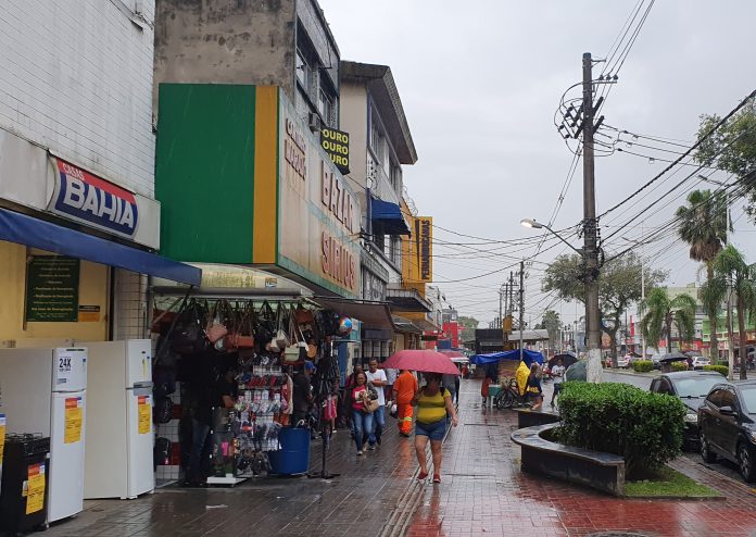 Pessoas caminhando em dia chuvoso em Cubatão