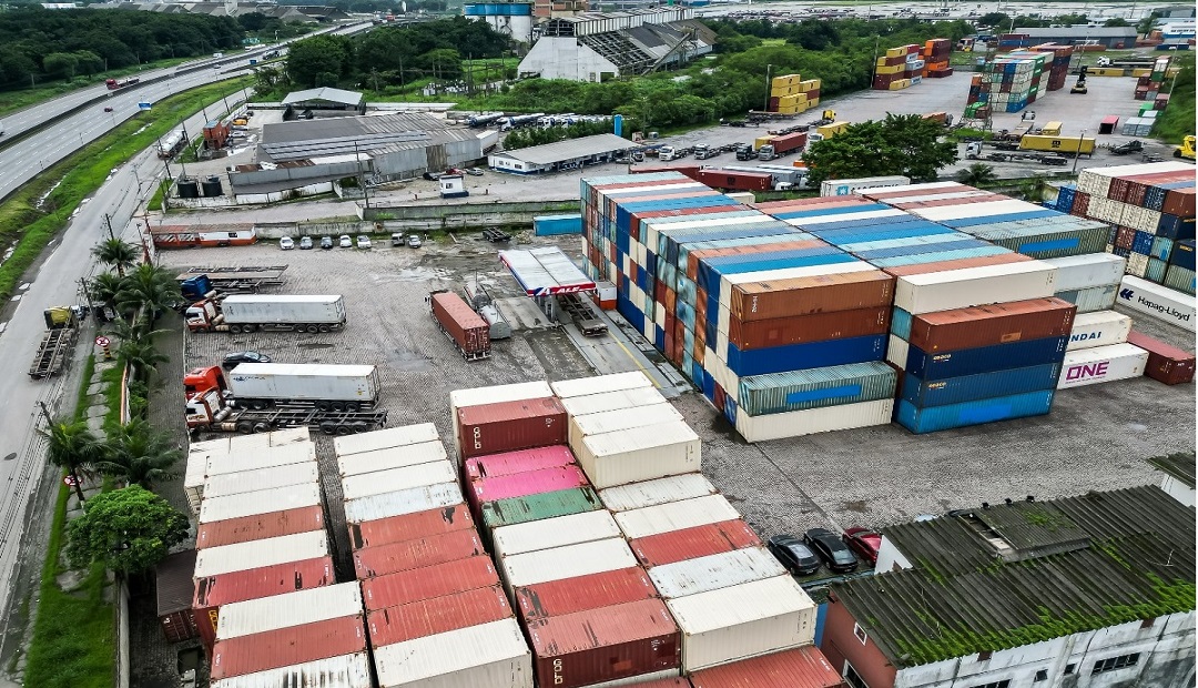 Pátio logístico com caminhões e contêineres em Cubatão